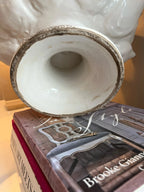 Heirbloom Studio ceramic artichoke pedestal bowl base showing rustic distressed detail on a stack of coffee table books