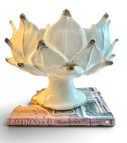 Heirbloom Studio off-white ceramic artichoke pedestal bowl with rustic distressed petal tips on stacked books